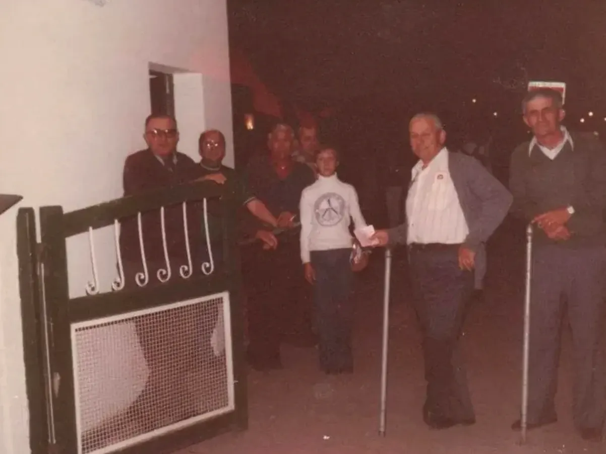 Foto histórica: grupo de personas en un portón durante la fiesta